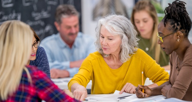 people sitting around a table discussing a paper