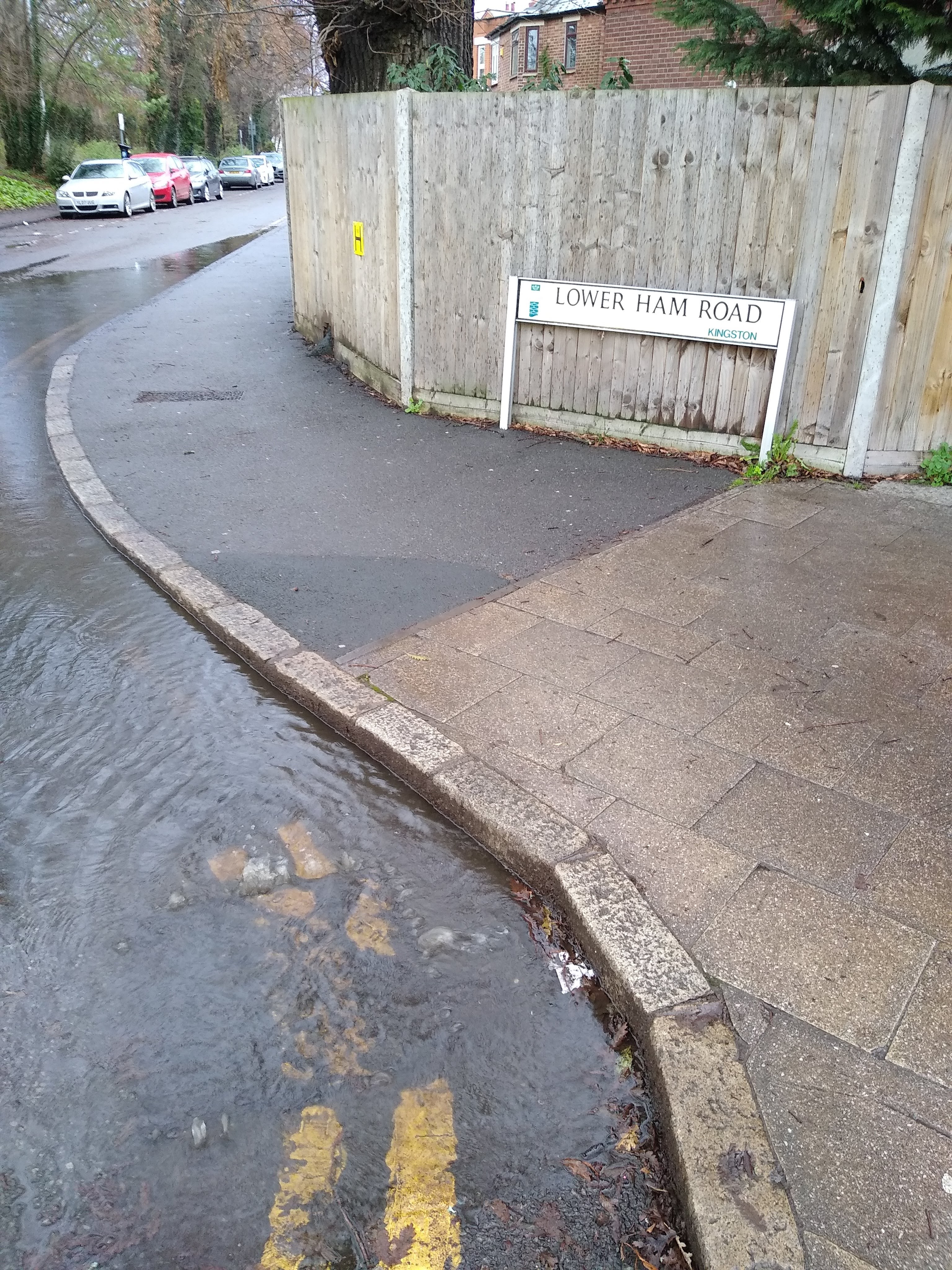 surface water flood showing rain water collected over the road and pathway 